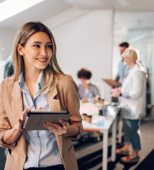 women smiling while holding tablet